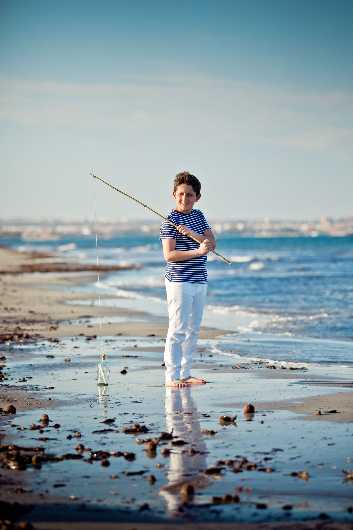 Sesión de comunión en la playa con aparejos de pesca